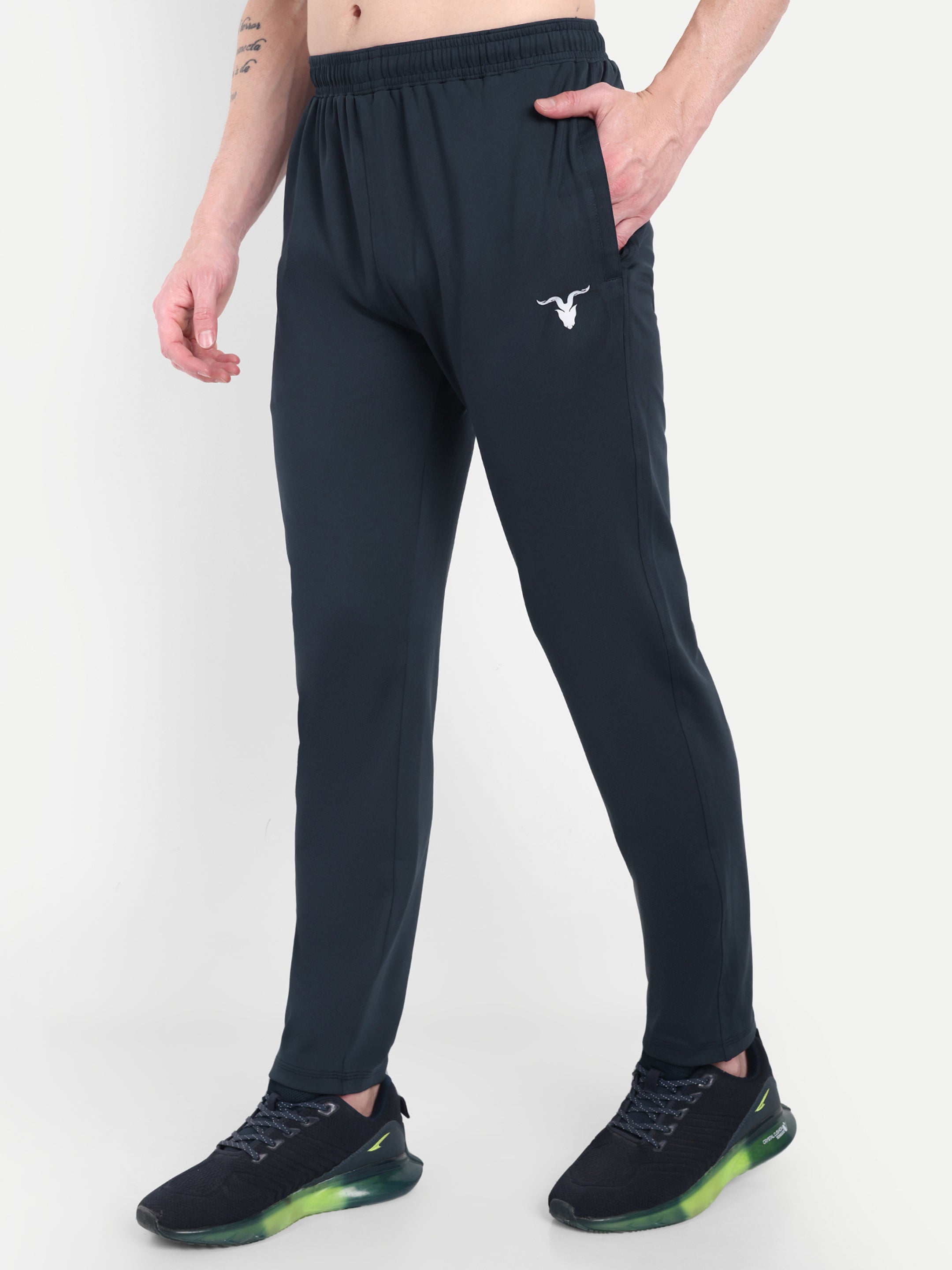 Person wearing black athletic pants with a logo on a white background